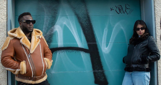 A stylish man wearing a classic shearling coat paired with a turtleneck sweater and leather boots, showcasing a warm and trendy winter outfit.