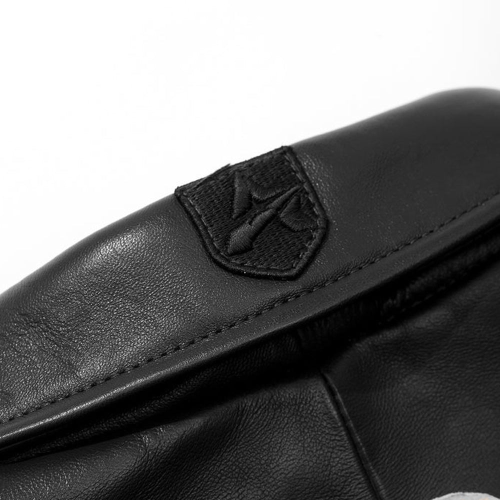 Close-up of a black leather glove with a brand logo on a white background
