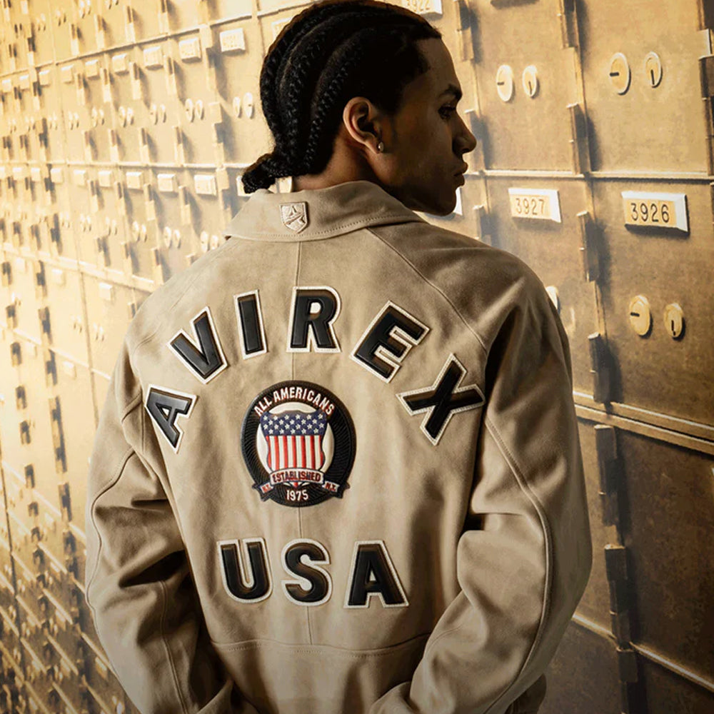 Person wearing an Avirex USA jacket in front of a textured wall.