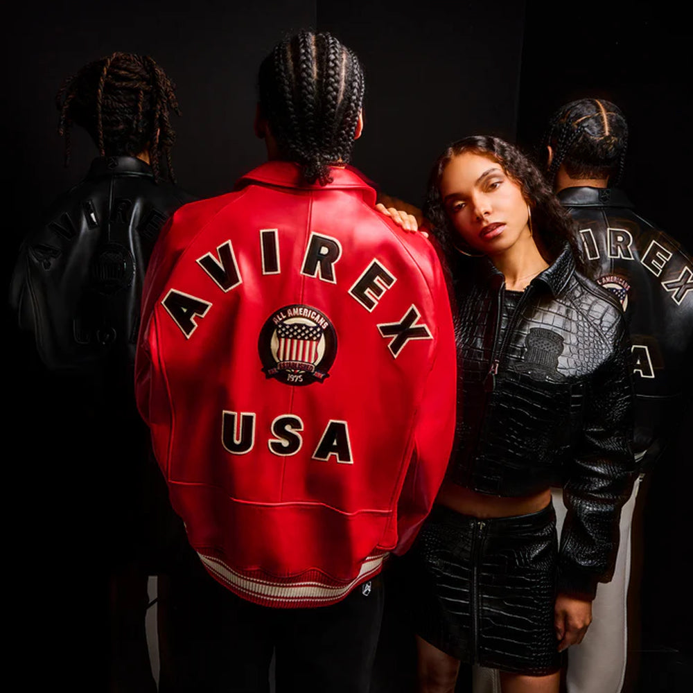 Person wearing a red 'AVIREX USA' jacket with another person in a black jacket, on a dark background.