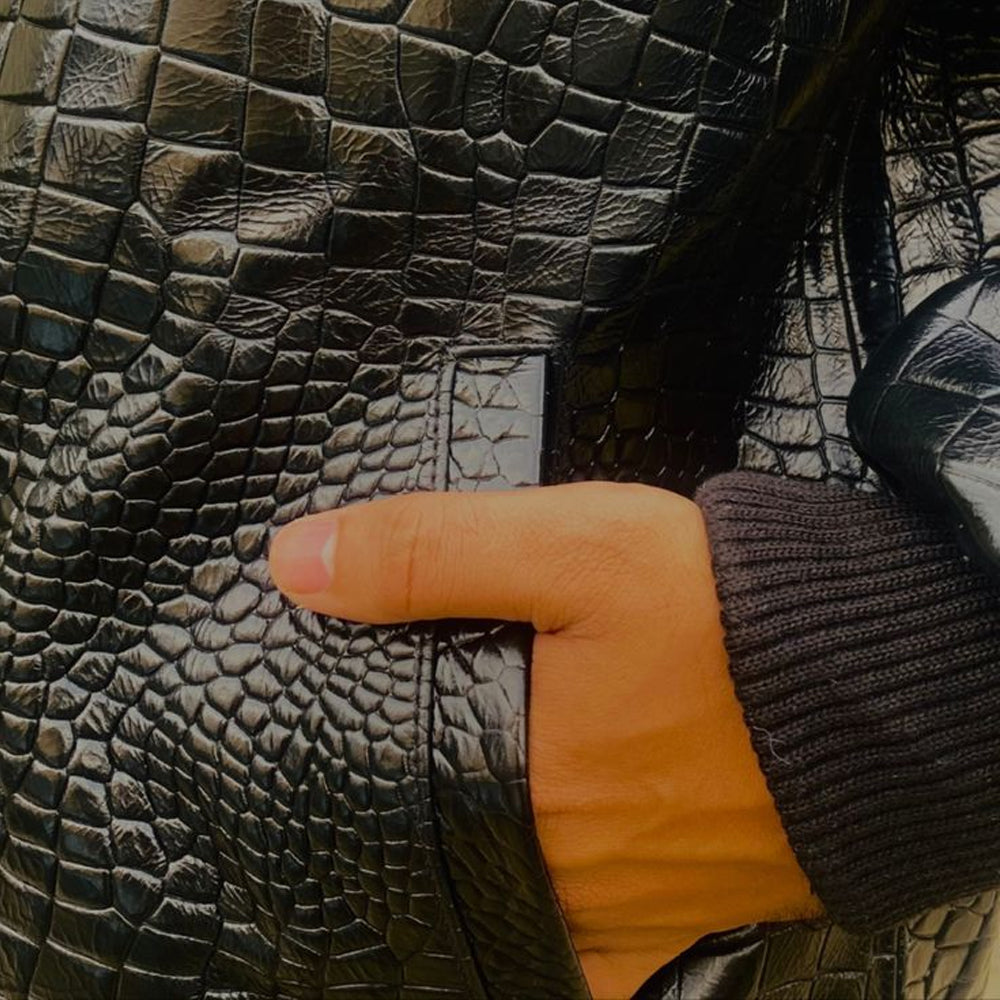 Close-up view of the jacketâs side pocket with a hand inside, showing the ribbed cuff and stitching detail.