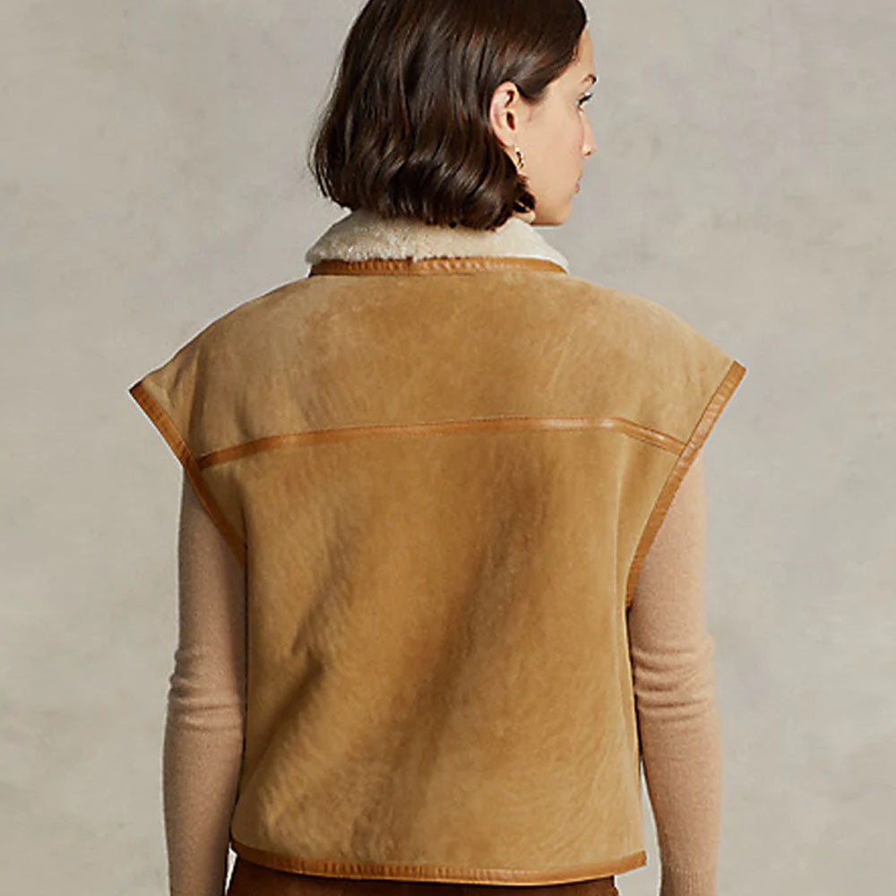 Woman wearing a brown shearling leather vest, back view highlighting the sleek and elegant suede finish.