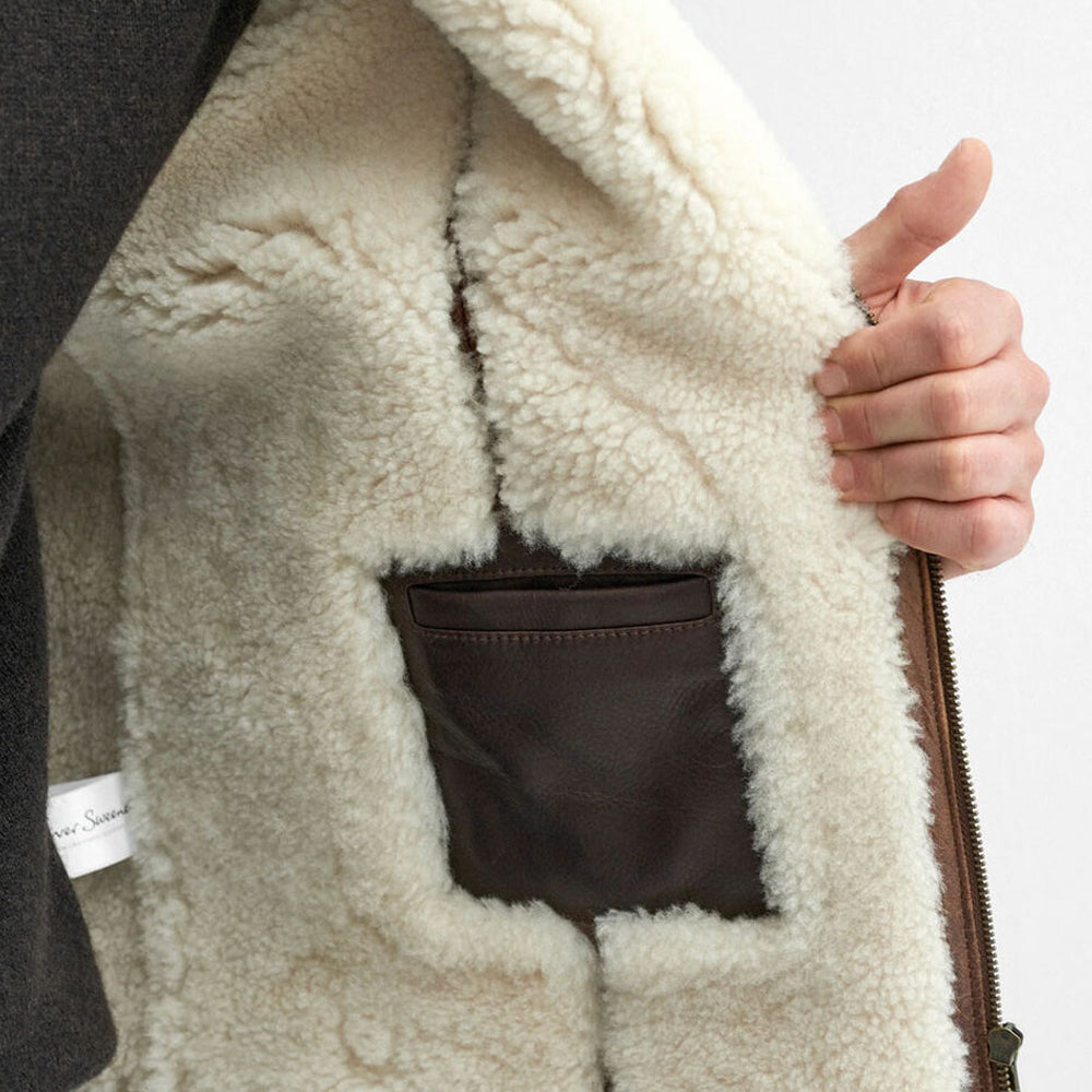 Luxurious shearling lining extending through the body, collar, and cuffs for unmatched warmth and comfort.
