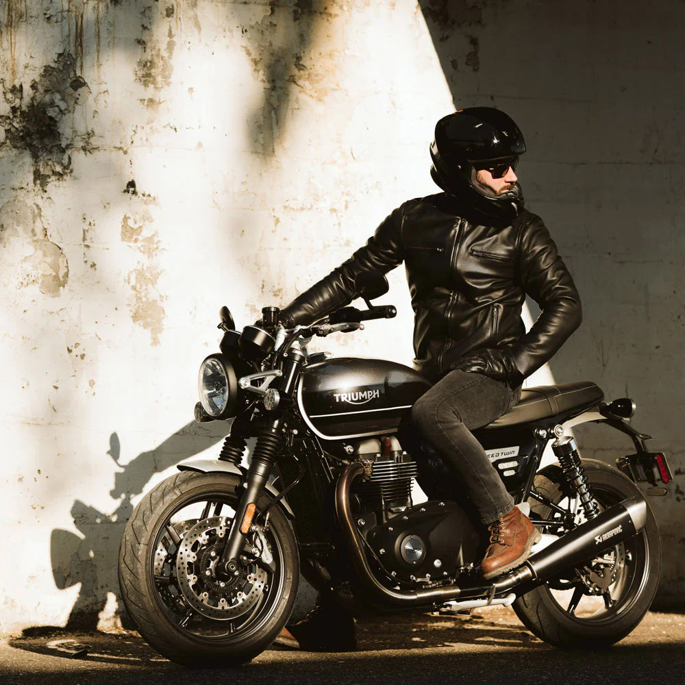 Man sitting on a bike wearing a men's vintage black bomber leather jacket.