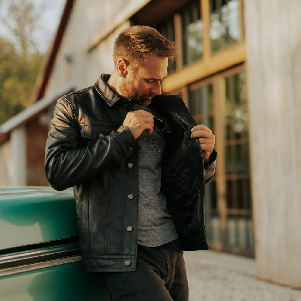Model wearing Men’s Black Lambskin Leather Trucker Jacket in casual setting for everyday style.