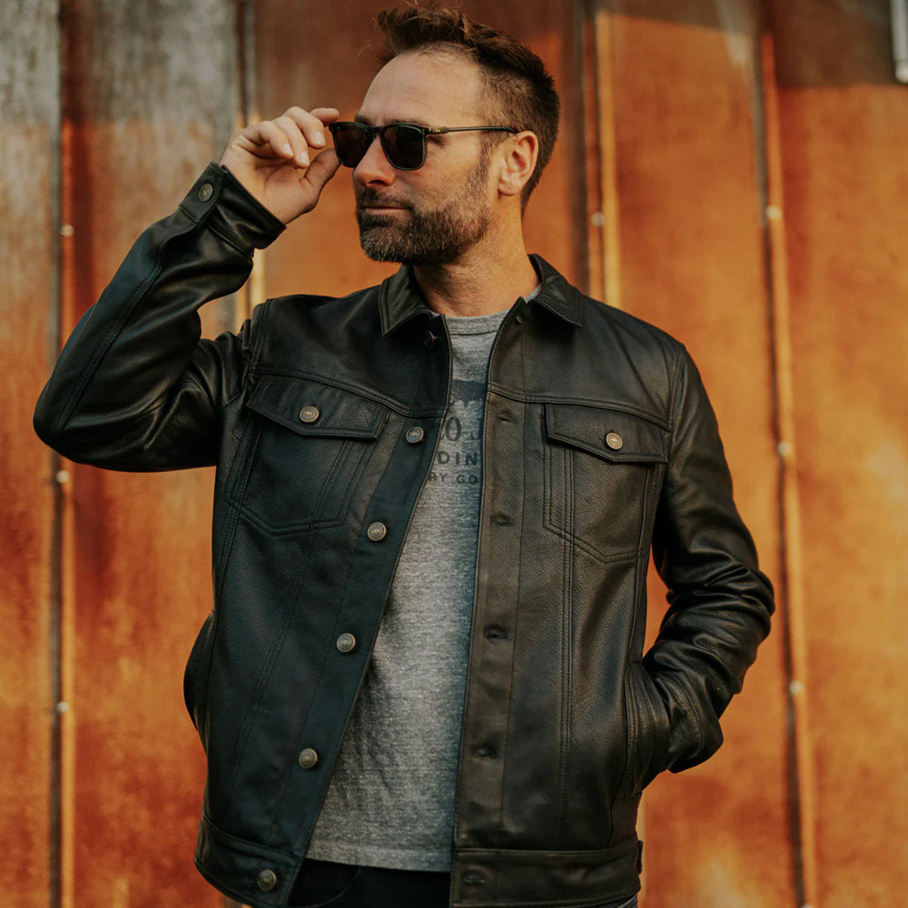 Model styling Men’s Black Lambskin Leather Trucker Jacket with jeans for a casual, fashionable look.