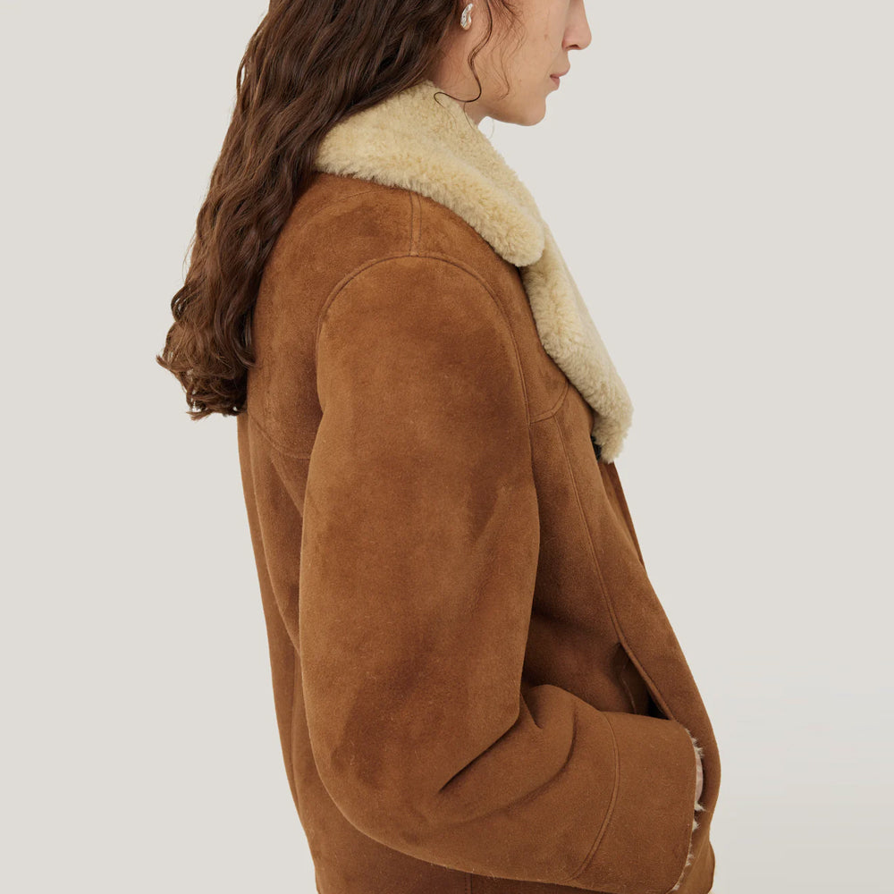 Detail shot of the earthy brown tone and stitching of the suede jacket.