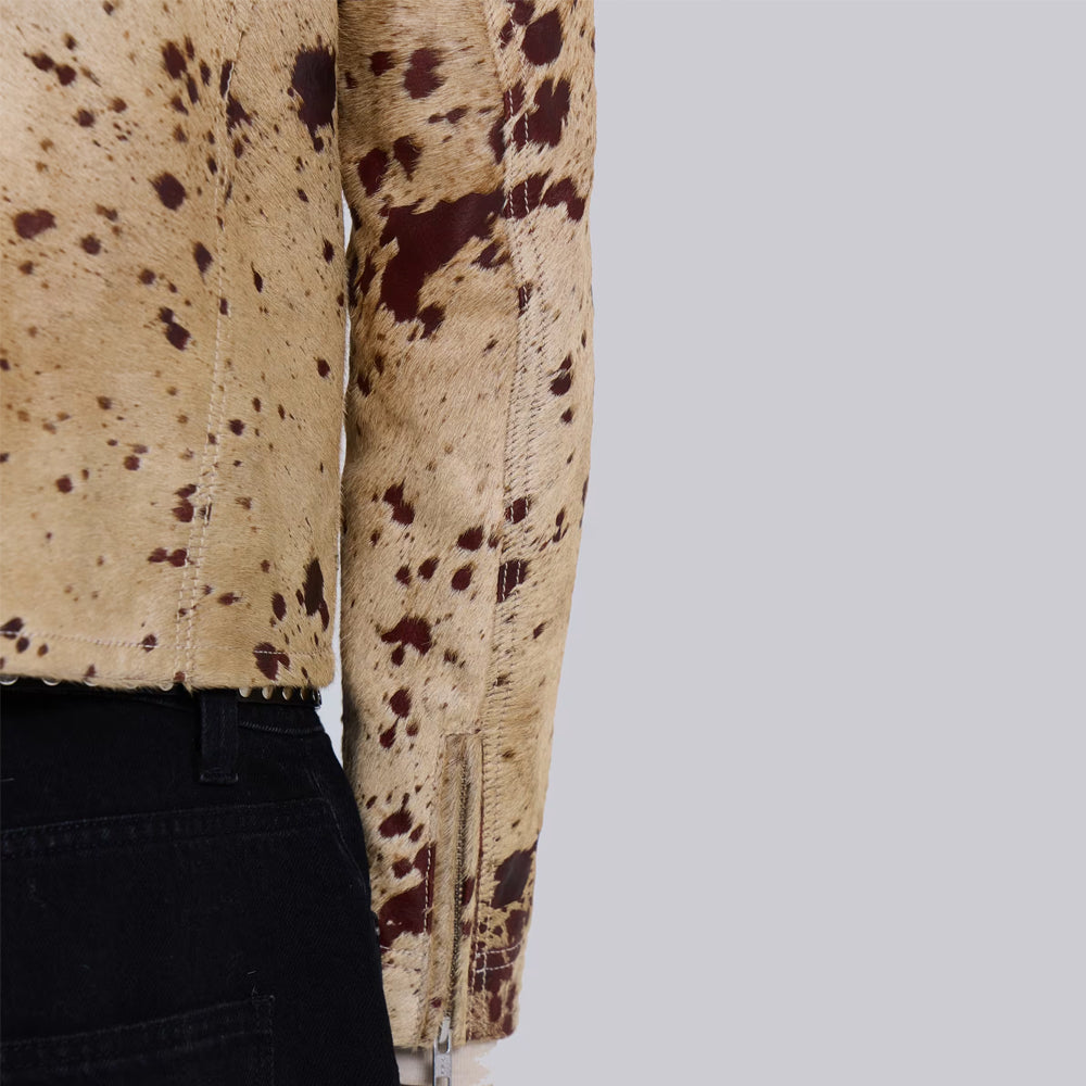 Close-up of adjustable sleeve zipper and tonal stitching on a speckled cowhide racer jacket