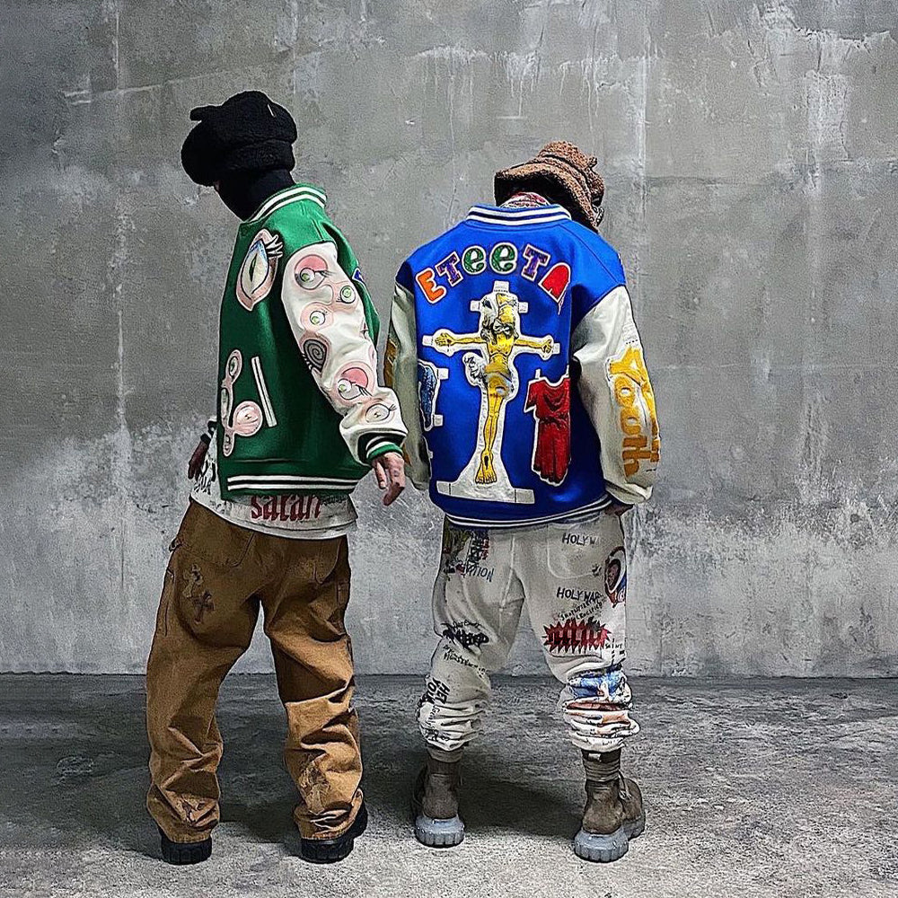 A man wearing the blue Damar Hamlin Super Bowl varsity jacket in a back pose, showcasing the streetwear fit and colorful Eternal embroidery.