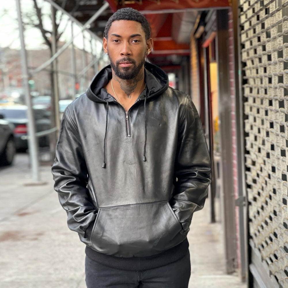 Straight front profile of the men's black leather pullover hoodie highlighting the metallic quarter-zip and kangaroo pocket.