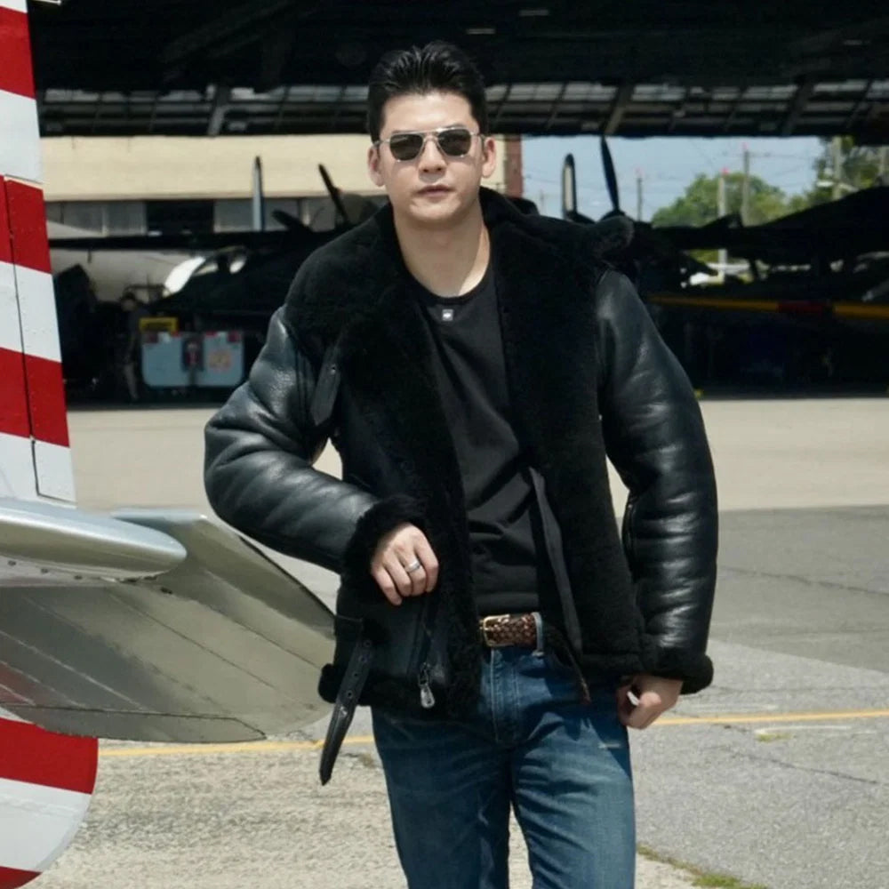 Male model wearing a black shearling aviator jacket beside an aircraft in an outdoor airfield setting