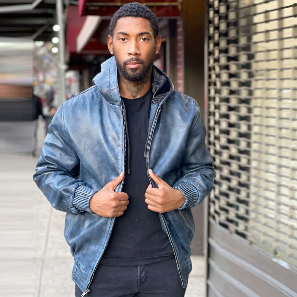 Men’s washed blue full-zip leather hoodie worn open, showing silver-tone hardware, black satin lining, shaped sleeves and knit cuffs.