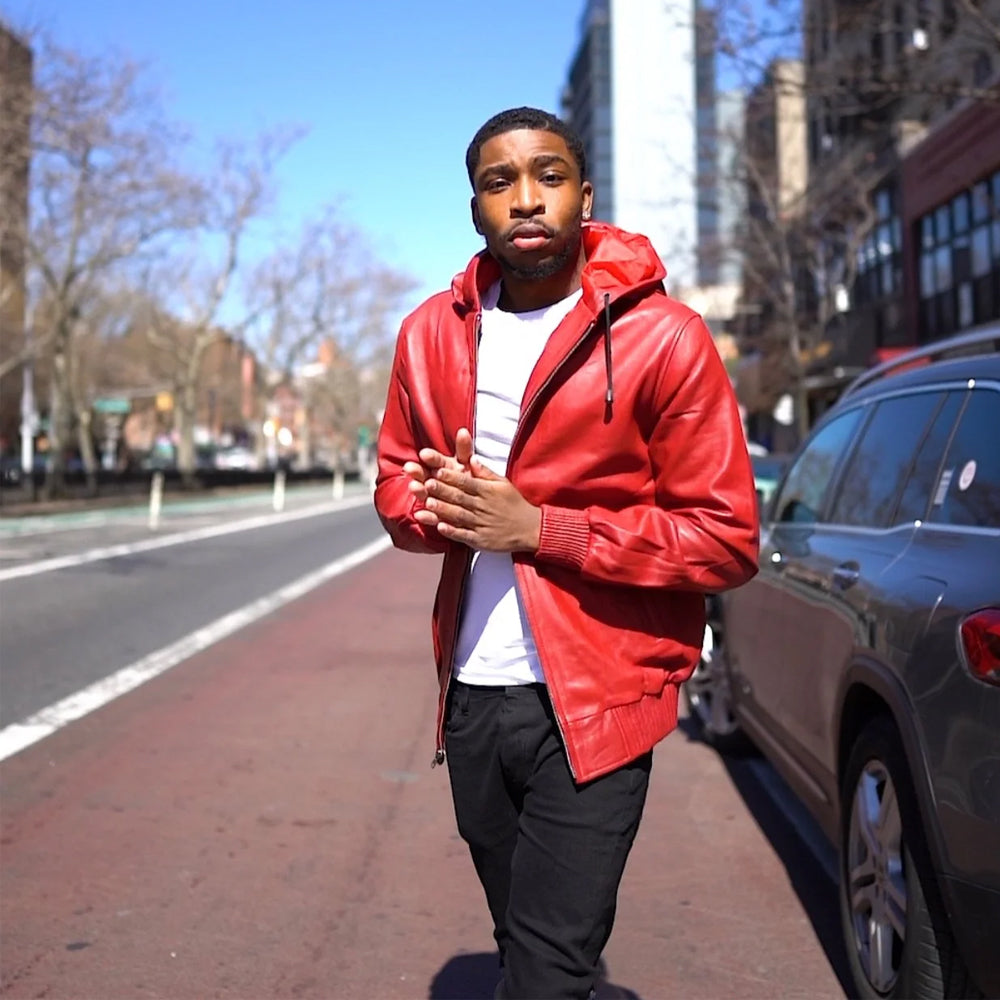 Street-style view of men’s bright red leather hoodie worn open with fixed drawstring hood, red rib-knit cuffs and waist trim.