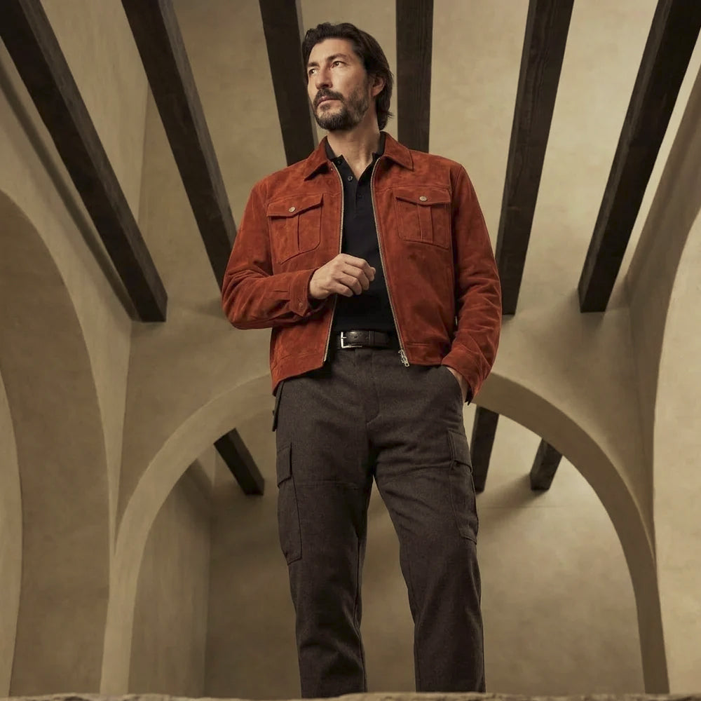 Full-length view of men’s rust lamb suede jacket styled with dark trousers, showing its straight hem and compact trucker proportions.