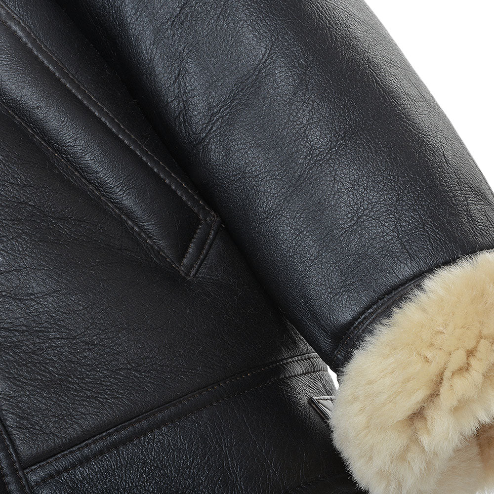 Macro close-up shot of fine pebbled black sheepskin leather grain texture and plush beige shearling wool cuff