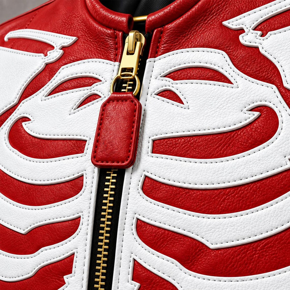 Close-up of stitched white rib-cage leather appliqué, red leather grain and gold-tone center zipper