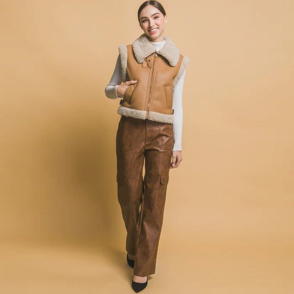 Womenâs cropped tan shearling aviator vest styled with a cream top and brown trousers