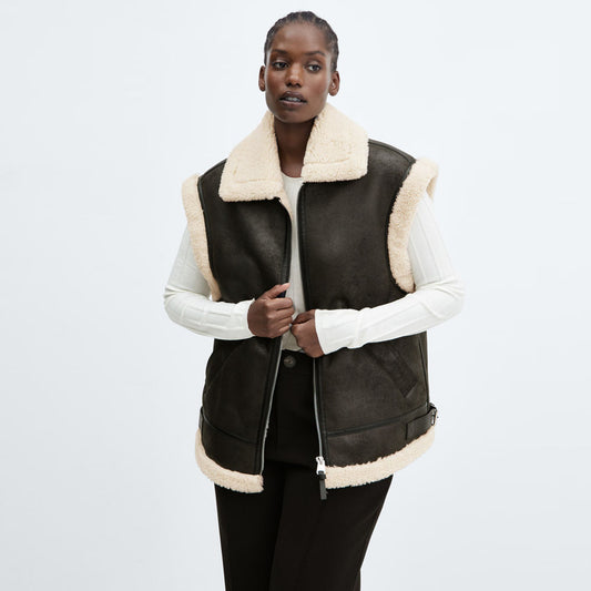 A stylish women’s shearling vest in dark brown color with soft wool lining, perfect for winter fashion.