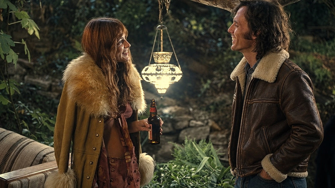 A man in a brown leather sheepskin aviator jacket beside a woman wearing a Penny Lane coat