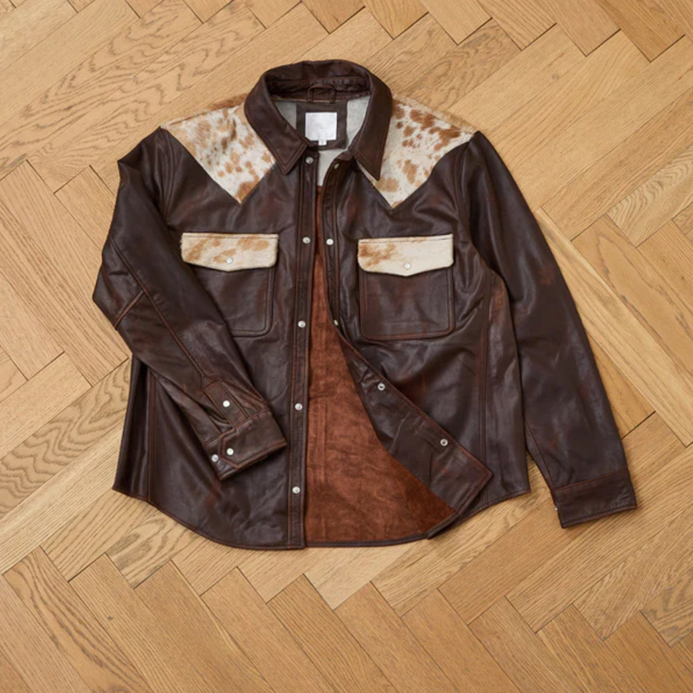 Brown leather jacket with white patches on a wooden floor