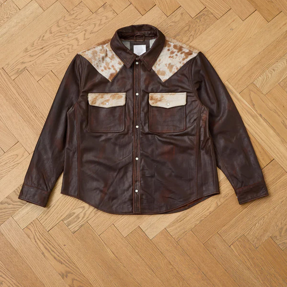 Brown leather jacket with cowhide accents on a wooden floor
