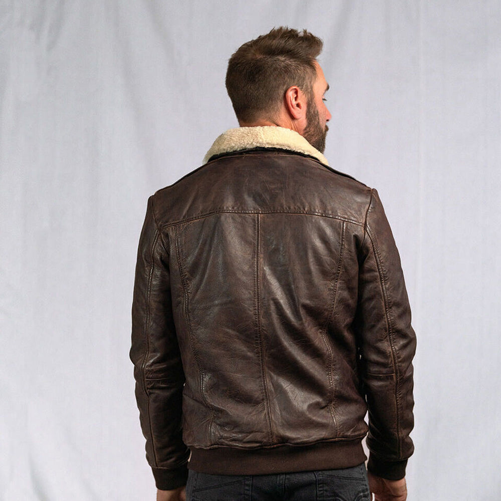 Back view of a man wearing the Men’s Vintage A2 Bomber Leather Jacket, showcasing its sleek design, removable fur collar, and ribbed cuffs.