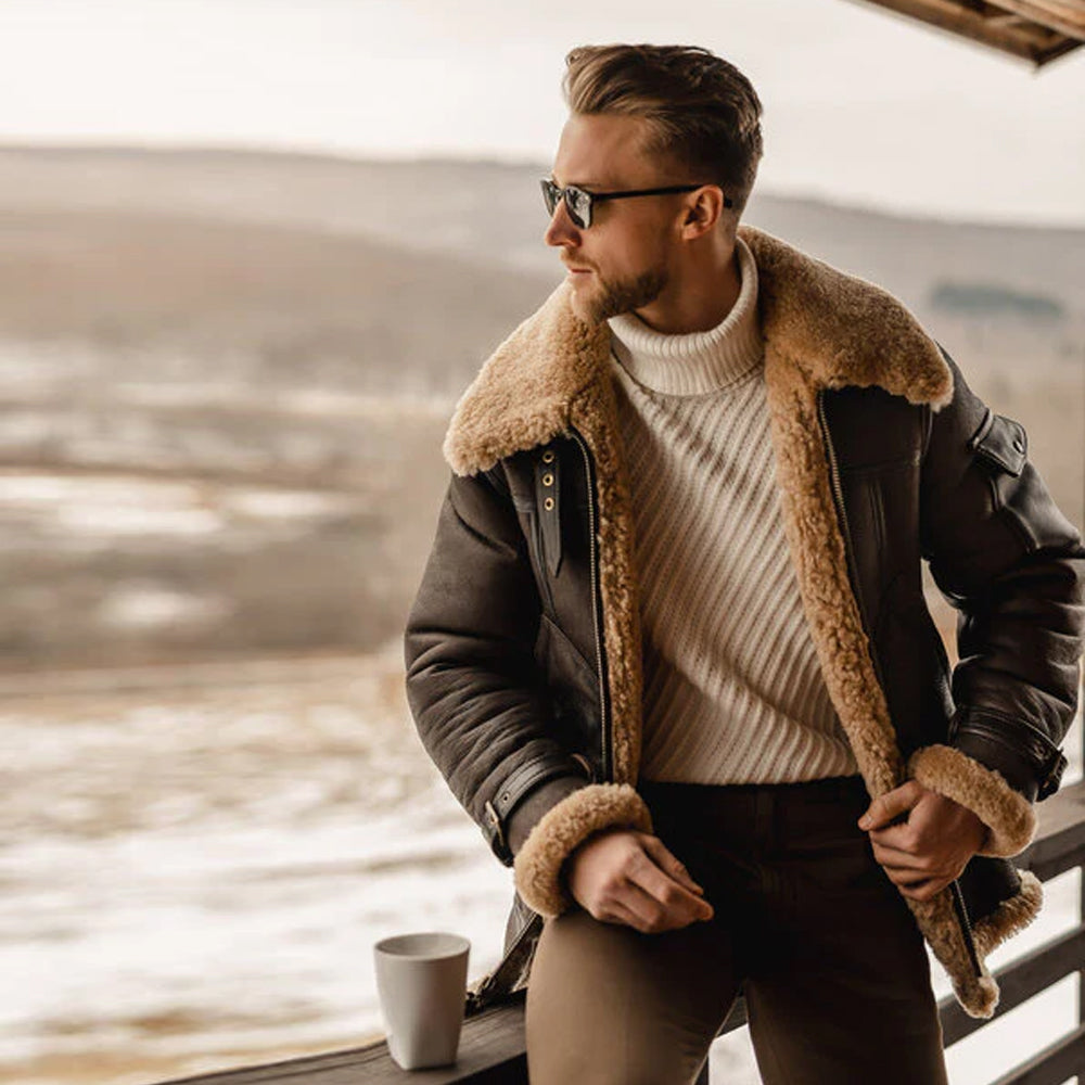 Man sitting while wearing the B3 Sheepskin Bomber Jacket, looking to the side, emphasizing its relaxed yet classic aviator style.