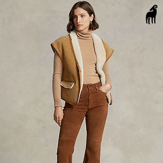 Woman wearing a brown shearling leather vest, front view showcasing the suede leather design and cozy faux fur lining.