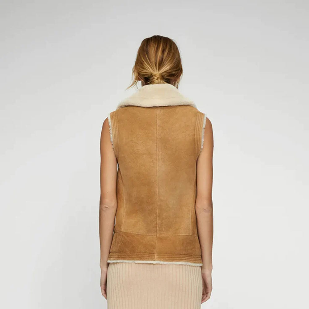 Model wearing women's shearling vest, back view, highlighting the mid-length design and fur lining.