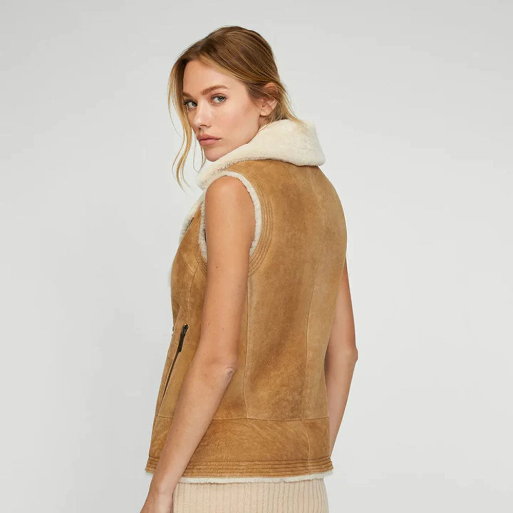 Detailed back view of the model in tan suede shearling vest with full zip closure and collared neckline.