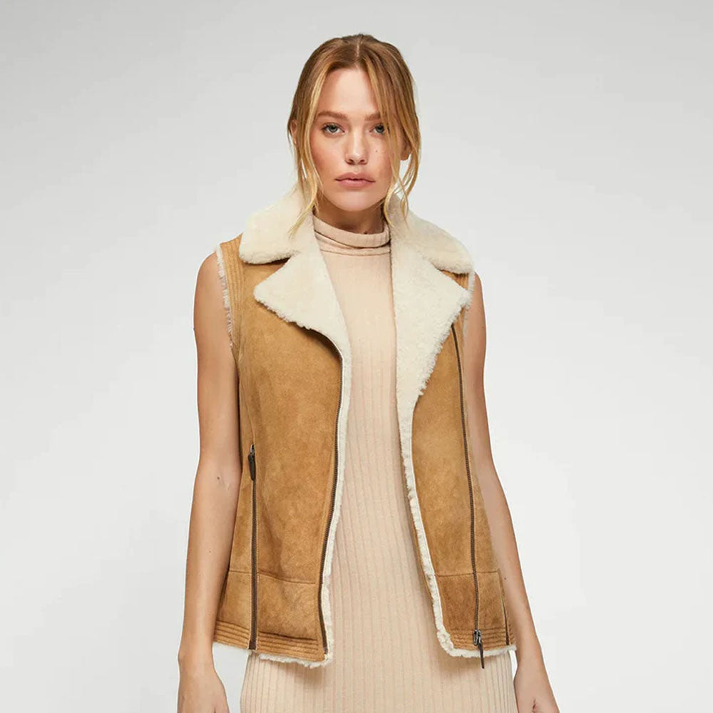 Close-up of the model in tan suede shearling vest, front view with biker-style design and fur trim accents.