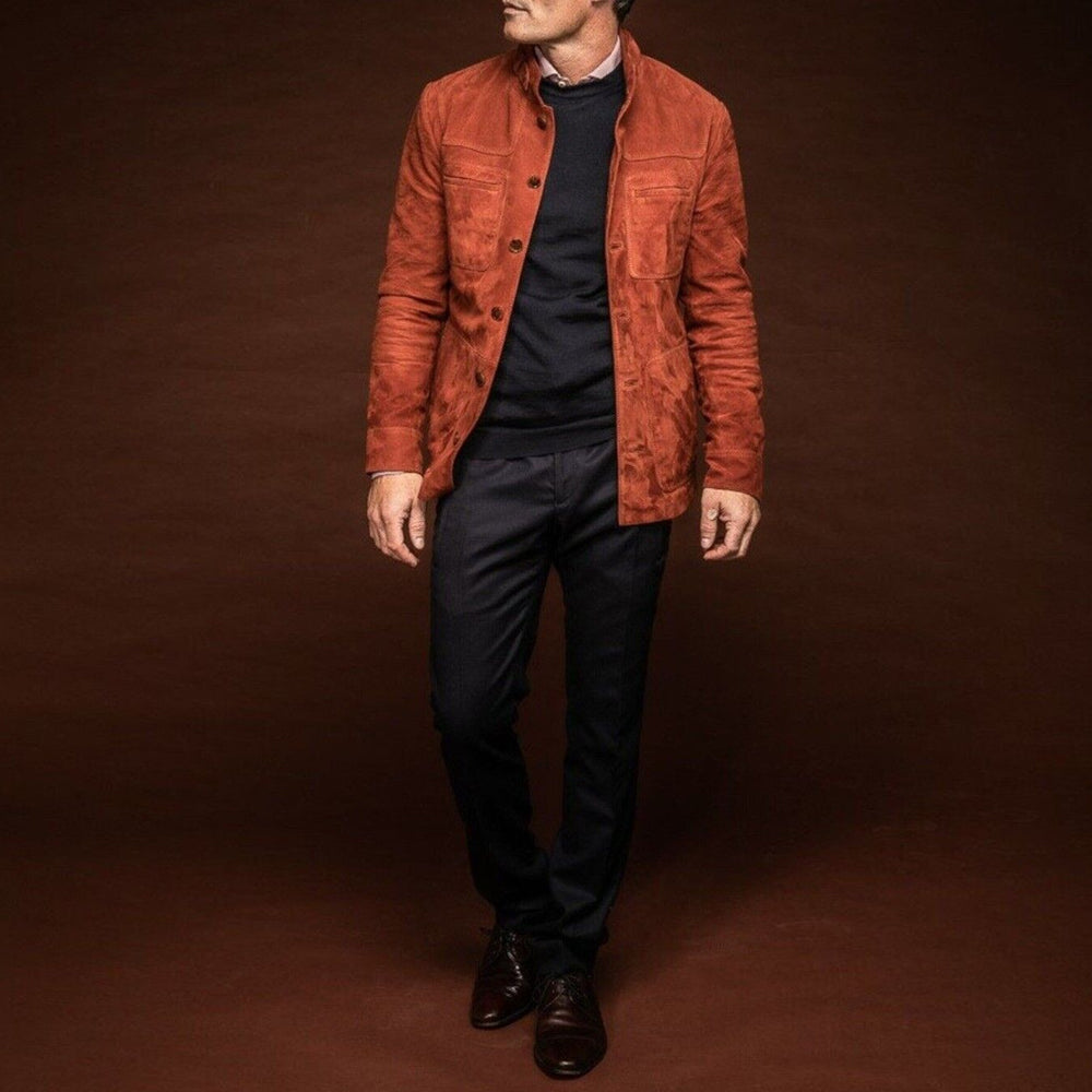 Man wearing a men's brown suede lambskin leather jacket with open buttons, paired with dress pants and shoes, showcasing a classy look.