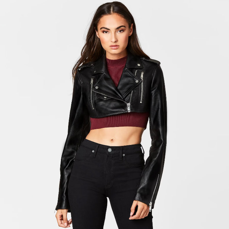 Woman wearing a black cropped leather biker jacket with a front zip and fitted silhouette