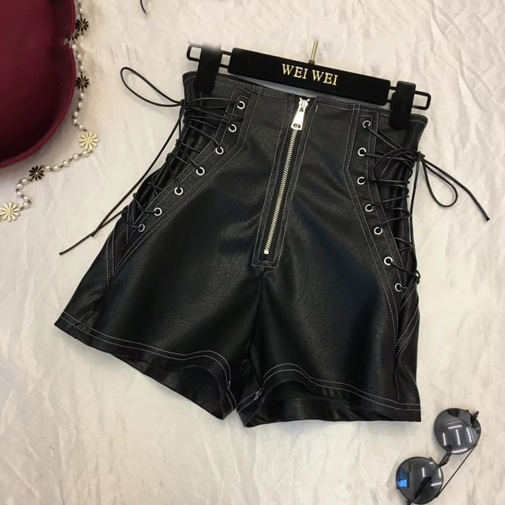 Women's black leather shorts laid flat, highlighting soft lambskin texture and intricate stitching.