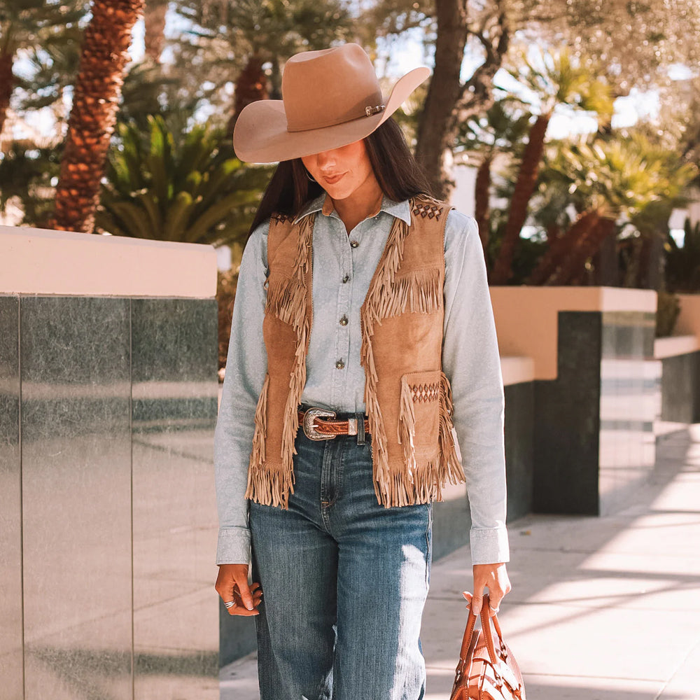 Front view of model wearing a camel brown suede leather fringe vest with handcrafted bead detailing.