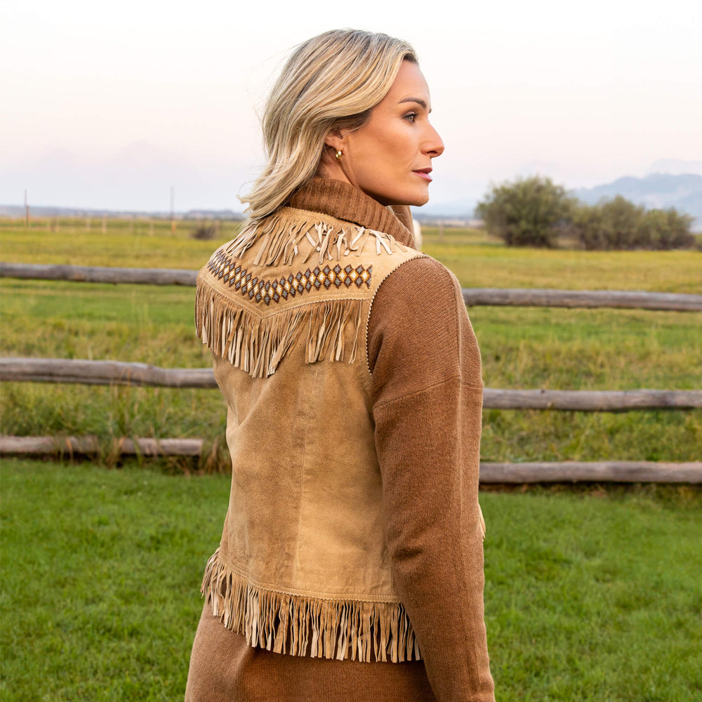 Back view of model wearing a suede fringe vest, showcasing the long fringe and detailed beadwork.