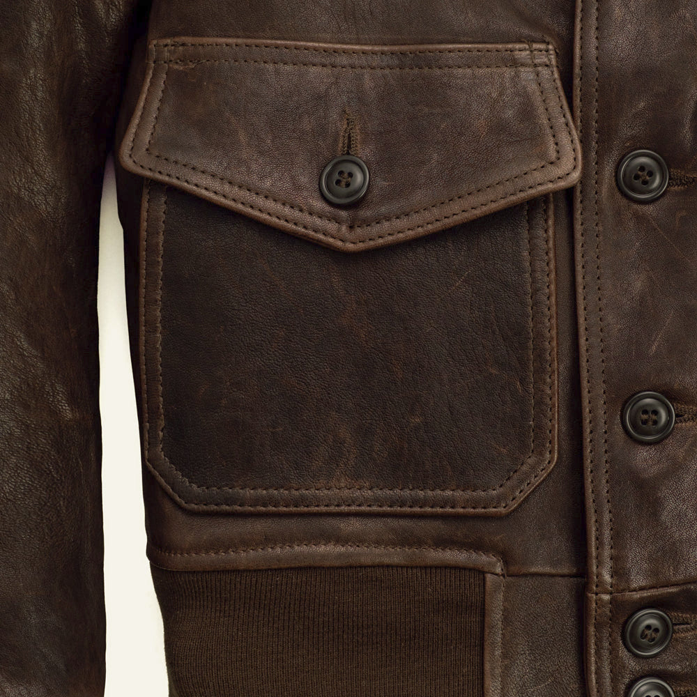 Macro view of the A-1 bomber’s pointed flap patch pocket, tonal button and double-row leather stitching