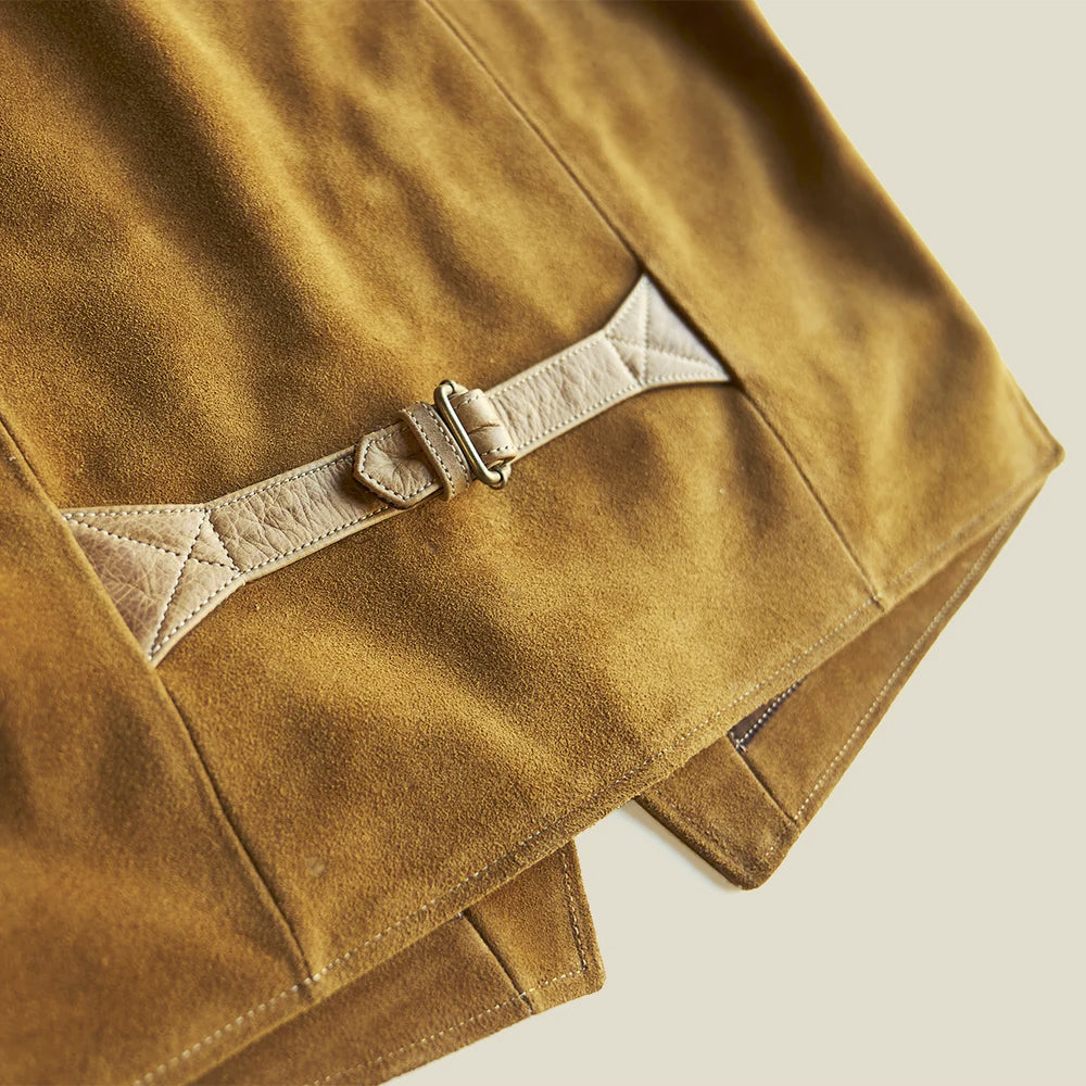 Angled close-up of the leather rear cinch with antique-brass buckle and cross-stitched triangular reinforcement