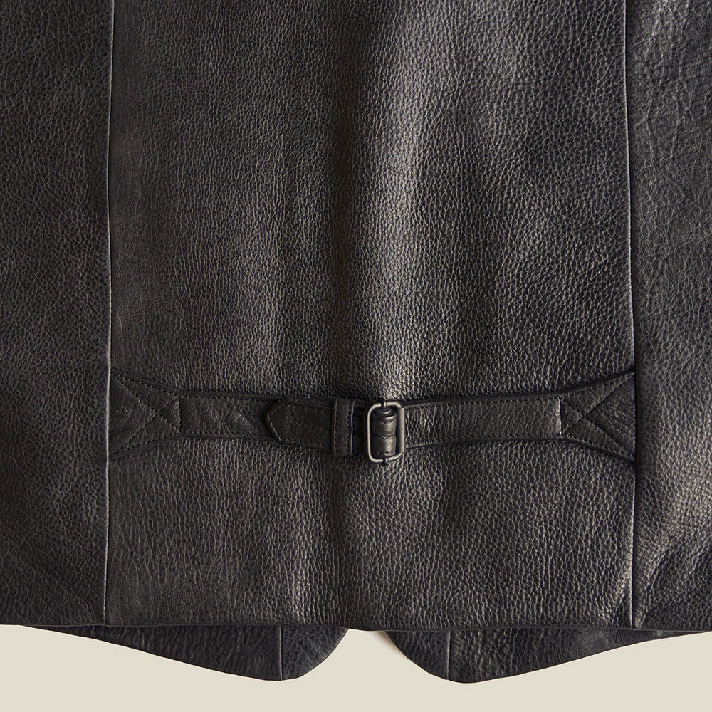 Close-up of American bison leather vest back cinch with metal buckle, reinforced triangular tabs and natural pebble grain