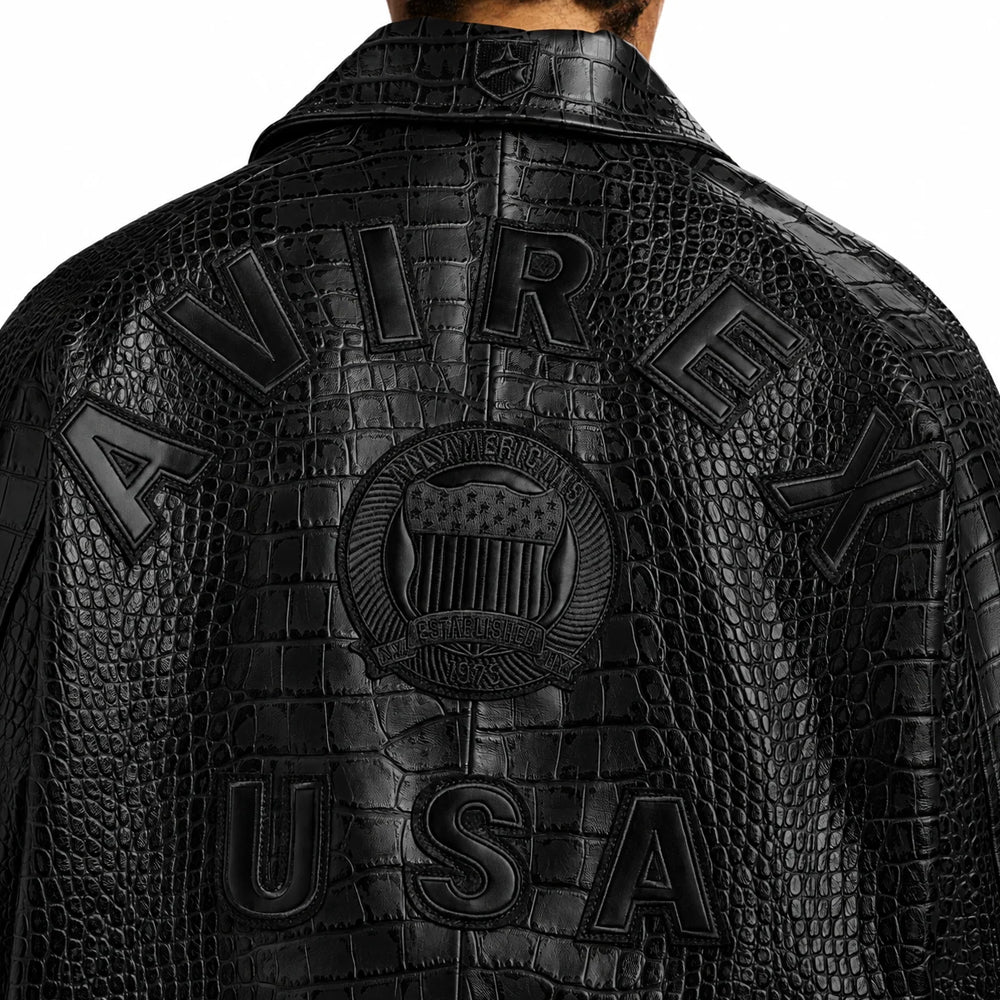 Close-up of raised black AVIREX USA back appliqués, circular shield emblem and rear-collar crest on croc-effect leather