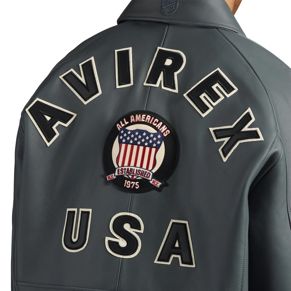 Close-up of charcoal jacket back with black and cream AVIREX USA appliqué plus embroidered All Americans shield emblem