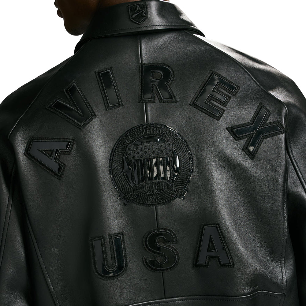 Close-up of black AVIREX USA leather appliqué and circular embroidered shield on smooth lambskin jacket back