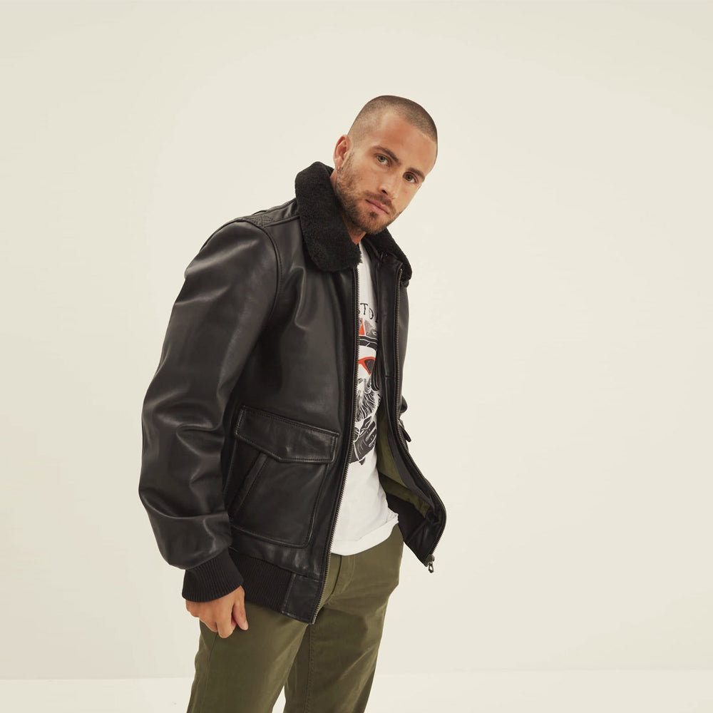 Three-quarter view of black sheepskin flight jacket showing smooth leather sleeves and large side-access utility pocket.