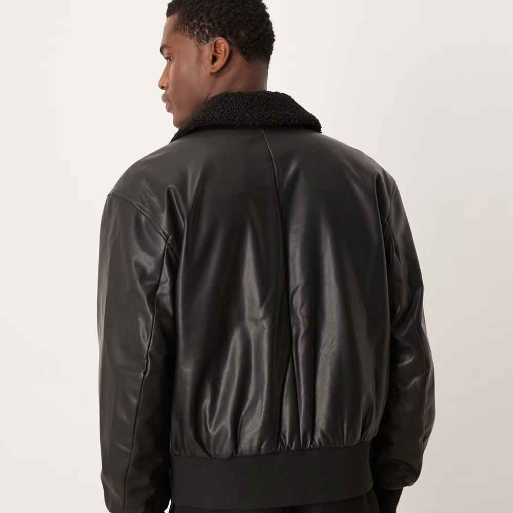 Rear model view of black sherpa-collar leather bomber showing center-back seam and gathered rib-knit waistband