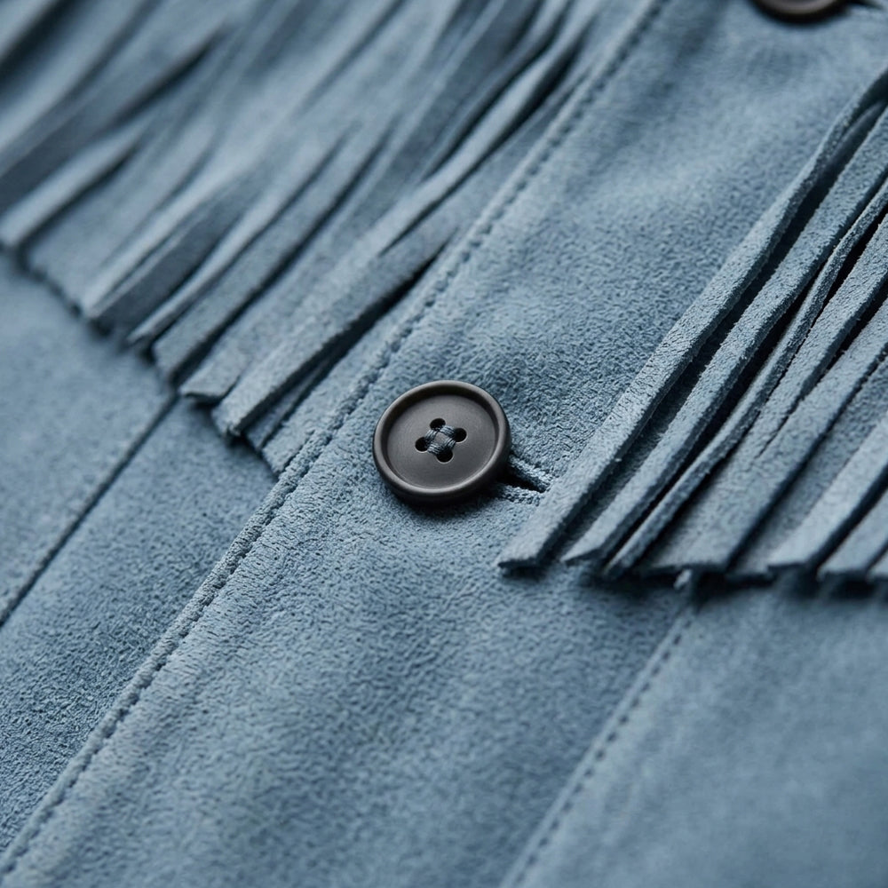 Macro detail of blue suede nap, tonal stitching, cut fringe and dark four-hole button