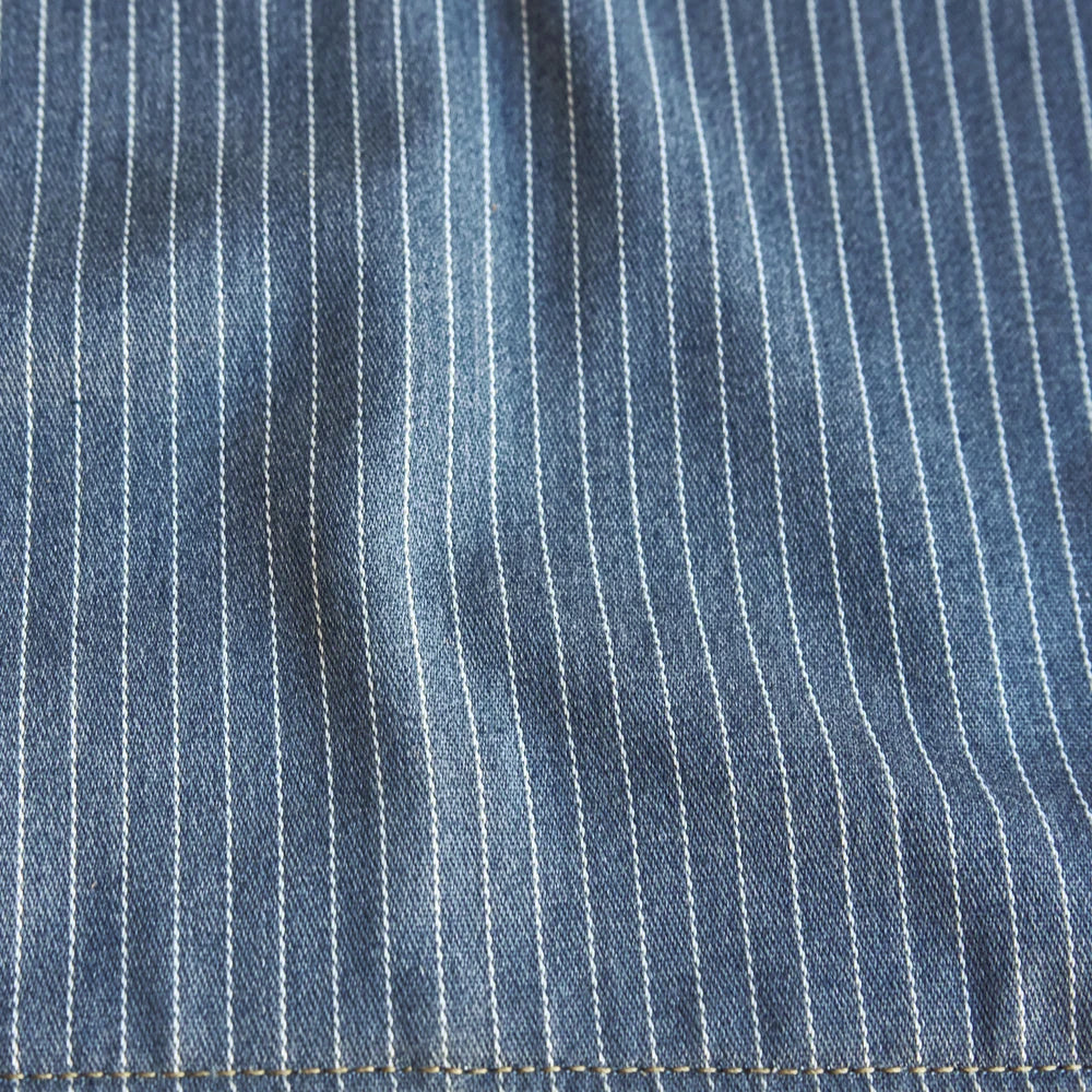 Close-up of the breathable blue-and-white vertically pinstriped chambray cotton vest lining