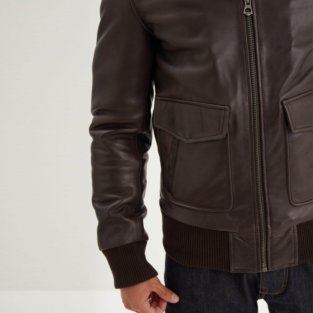 Close-up of brown aviator jacket dual-entry pocket, shaped snap flap, side hand channel and ribbed waist.