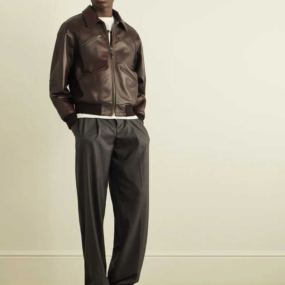 Model wearing the regular-fit brown waxed leather flight bomber with four diagonal pockets and dark ribbed hem
