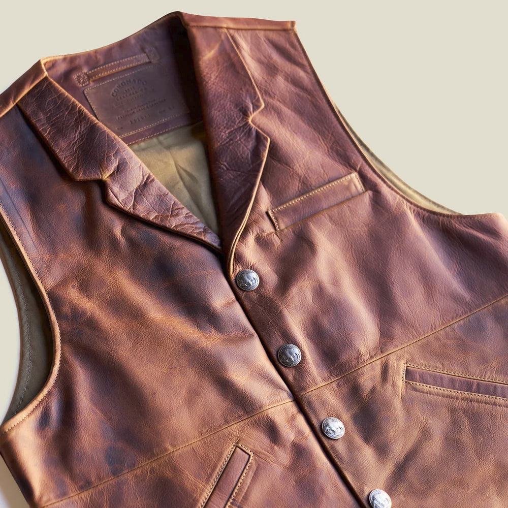 Close-up of men’s steerhide Western vest highlighting Buffalo Nickel-style snaps, lapel construction and natural pull-up patina