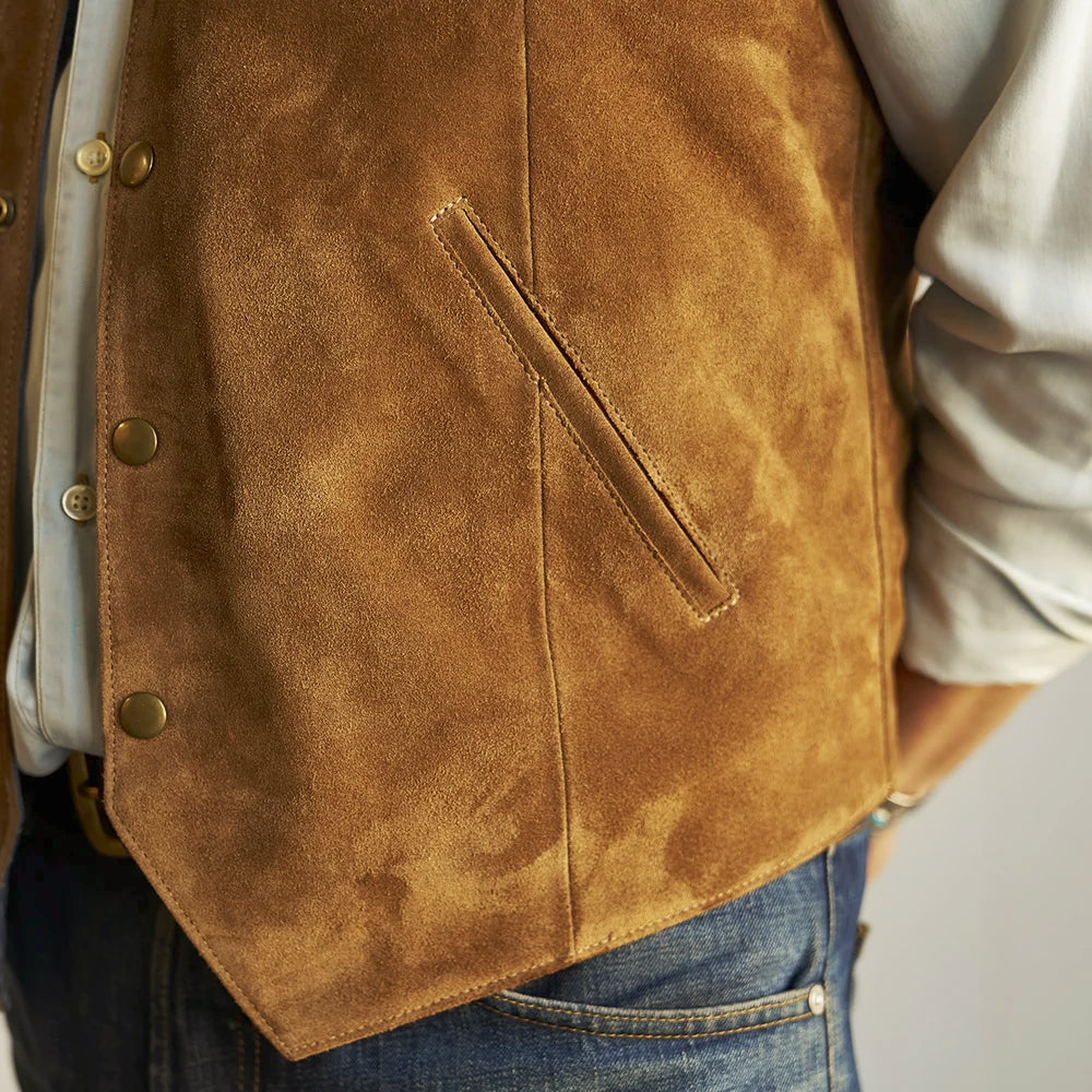 Detailed view of caramel-brown suede shading, angled pocket construction and pointed lower front edge